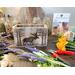 A wood moose box made with upcycled gray wood. It is shown on my work table surrounded by cut faux wildflowers. 